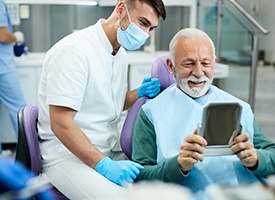 Man smiling at reflection in mirror with dentist