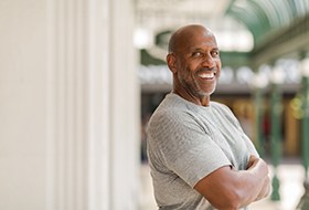 Man in gray shirt smiling outside
