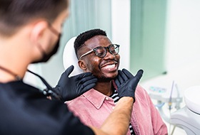 Dentist looking at patient's smile in treatment room