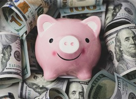Piggy bank on hundred dollar bills