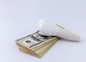 Money and dental implant representing the cost of dental implants in Pittsburgh