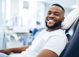 happy male dental patient in treatment chari