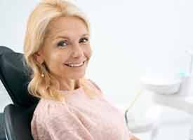 Woman in pink sweater sitting in the dentist’s chair