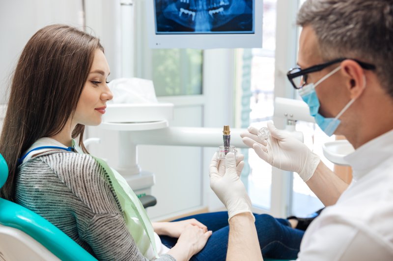 Patient talking with her dentist about a loose dental implant